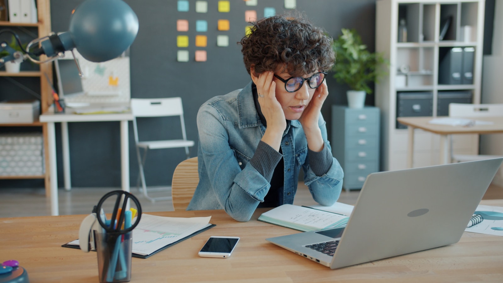 A person looking stressed while working at a laptop